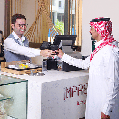 Saudi guy paying at hotel reception