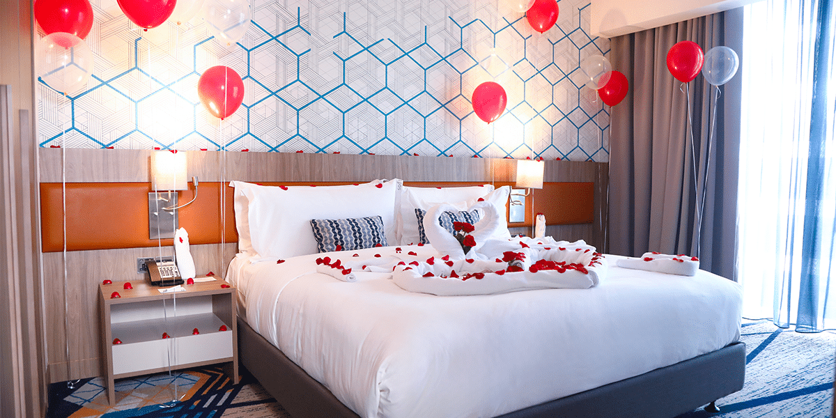Hotel room, with romantic ambiance, decorated with red balloons and red flower petals
